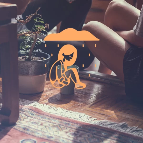 Dos personas sentadas en el suelo bajo una sombrilla, mostrando cómo vivir con alguien que sufre ansiedad y depresión.