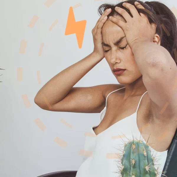 Una mujer está sentada en una silla de oficina con las manos en la cabeza.