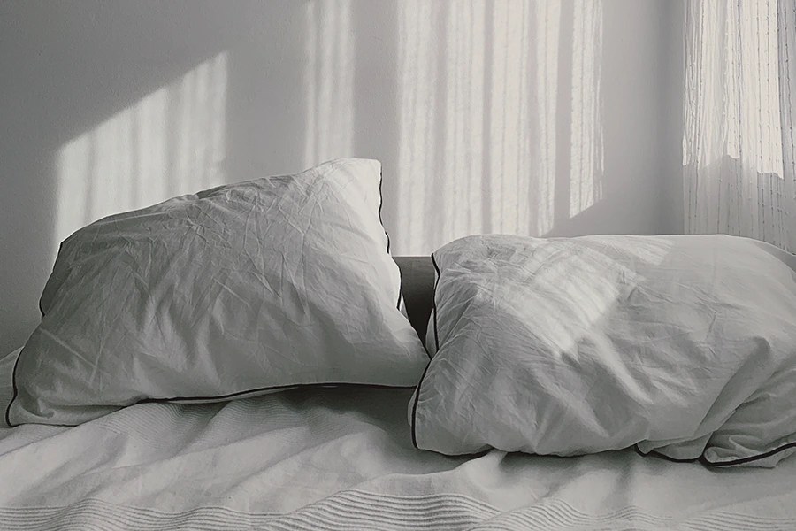 Las almohadas blancas sobre una cama blanca brindan una atmósfera tranquila y pacífica, perfecta para quienes luchan contra el insomnio inducido por la ansiedad.