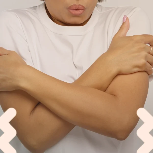 Una persona que se abraza a sí misma con los brazos cruzados sobre el pecho, demostrando temblores de ansiedad.